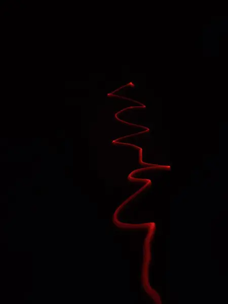 Disparo Vertical Una Luz Neón Roja Sinuosa Aislada Oscuridad Para — Foto de Stock