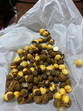 Beyaz bir plastik torba üzerinde kavrulmuş bir yığın chana 'nın dikey yakın çekimi