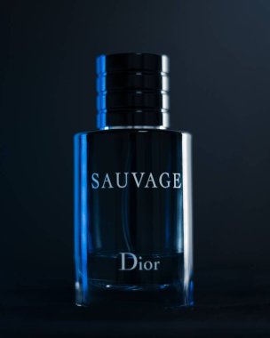 Dior Sauvage parfümünün koyu arkaplandaki dikey görüntüsü.