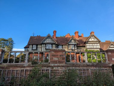 Bir sürü penceresi ve çiti olan büyük bir tuğla bina.