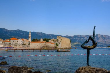 Arka planda eski Budva kasabasının Dansçı heykeli var. Karadağ.