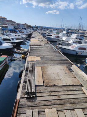 Her iki tarafında tekneler olan eski bir ahşap limanın dikey görüntüsü.