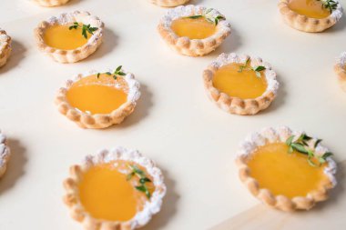 Tahta bir tabakta sayısız küçük limonlu tart.