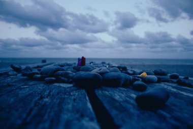 Arka plandaki rıhtımda kayaların yakın çekimi.