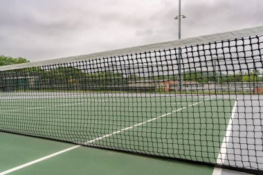 Beyaz çizgileri olan yeni açık yeşil tenis kortları.