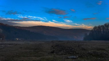 Gün batımında Romanya 'daki dağların yakınlarındaki güzel bir ormanın alçak açılı görüntüsü