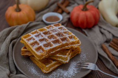 Kahvaltı için beyaz pudralı bir tabakta lezzetli waffle 'ların yakın çekimi.