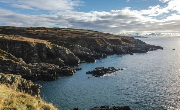 晴れた日には青空を背景に穏やかな海に囲まれた大きな崖 — ストック写真