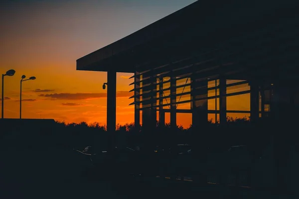 Ένα Γραφικό Ηλιοβασίλεμα Πάνω Από Ένα Κτίριο Σταθμευμένα Αυτοκίνητα Μπροστά — Φωτογραφία Αρχείου