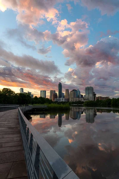 A vertical shot of TX skyline at sunset from the boardwalk along Town Lake in Austin city
