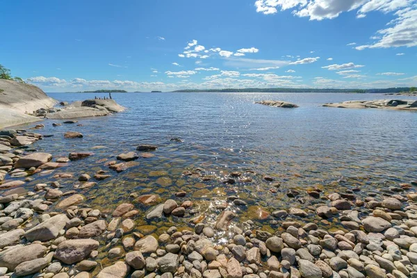 湖の近くに美しい石の風景 背景に澄んだ空 — ストック写真