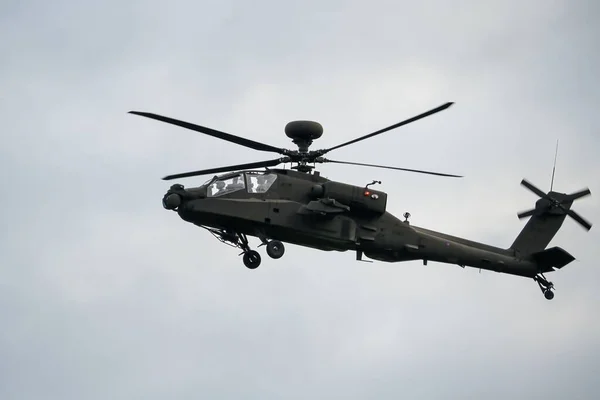 暗い灰色の軍隊が曇った空に向かって飛行中のヘリコプターを攻撃する — ストック写真
