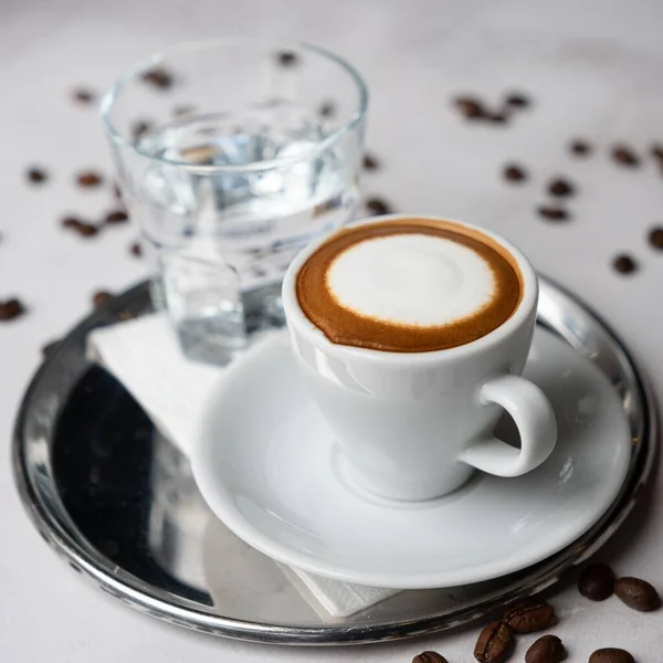 Uma Xícara Café Branco Copo Água Uma Placa Metal Fundo — Fotografia de Stock