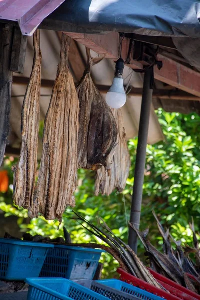 A vertical shot of a booth in the market selling dried and fresh fish