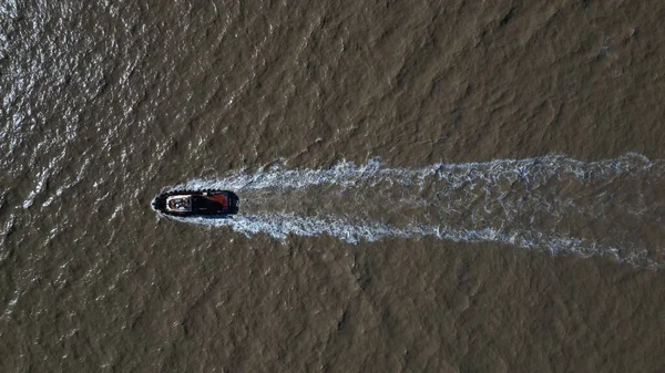 汚れた水の上をスピードアップするボートの空中ドローンの眺め — ストック写真