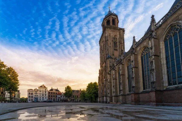 オランダのデヴェンターにある聖レビュヌスプロテスタント教会の低い角度に散在する雲に対して — ストック写真