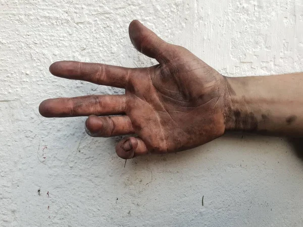 白いコンクリートの壁の背景に汚れた手の閉鎖 — ストック写真