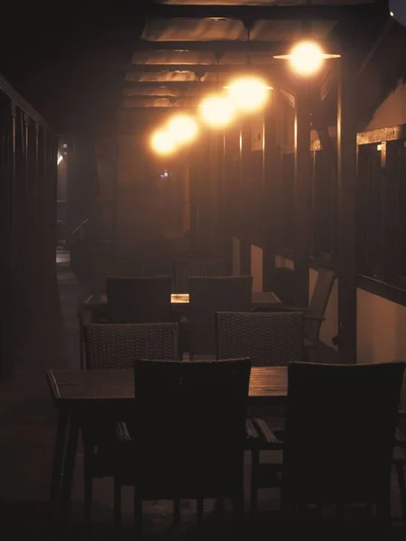 夜间在圆灯泡下的咖啡店的垂直照片 — 图库照片