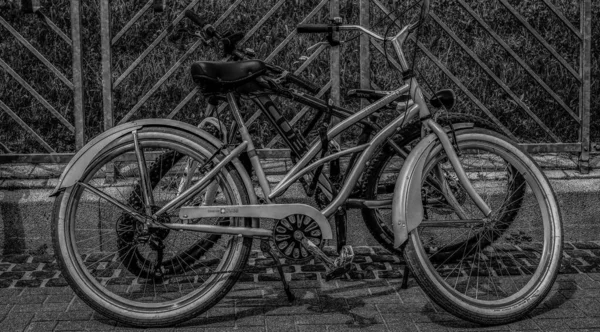 Монохромный Снимок Двух Велосипедов Припаркованных Улице Солнечный День — стоковое фото