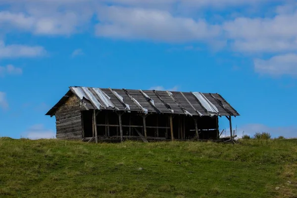 緑の丘の上にある古い廃屋の風光明媚なショット — ストック写真