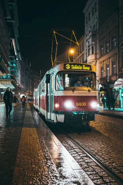 Вертикальный Снимок Старого Трамвая Едущего Улицам Праги Дождливой Ночью — стоковое фото