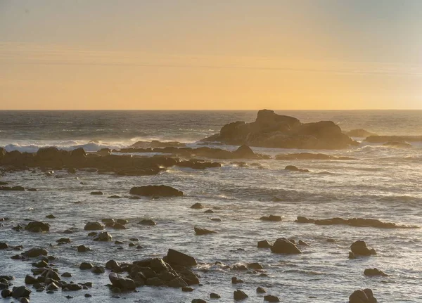 橙色落日时 在海洋中央的岩石特写 — 图库照片