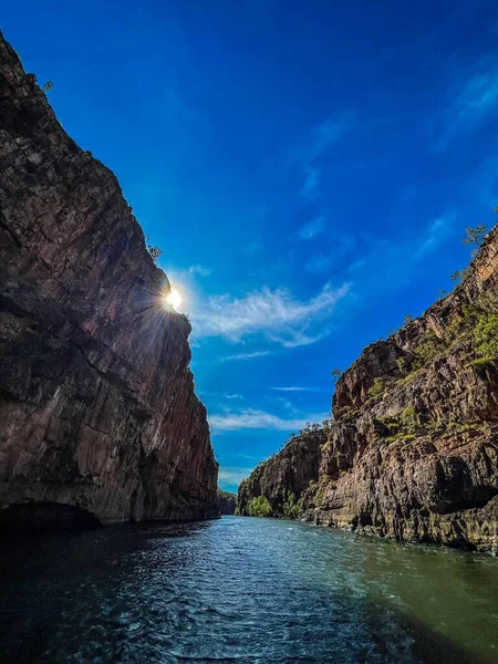 一道在阳光和蓝天下被悬崖峭壁环绕的河流的垂直截图 — 图库照片