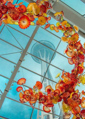 Bir Space Needle 'ın dikey yüksek açılı görüntüsü müzenin camına saplanmış ve Amerika Birleşik Devletleri Seattle' da çok güzel turuncu bir sanat eseri.