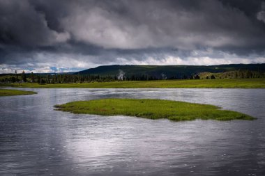 Yellowstone nehrinin güzel bir manzarası ve etrafında bir dağ sırtı.