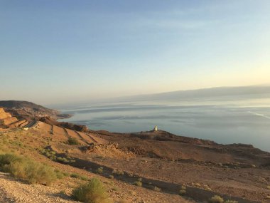 Gün ışığında kıyı şeridi üzerinde kuru kum bulunan manzaralı bir manzara.