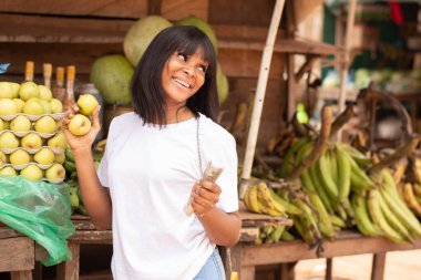 Güzel bir Nijeryalı kadın elma alıyor.