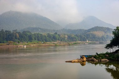 Luang Prabang, Laos 'taki dağların yakınında yüzen bir tekneyle Mekong Nehri' nin güzel bir görüntüsü.