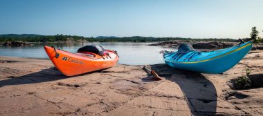 Gürcistan Körfezi 'nin pürüzsüz granitine park etmiş kanolar. Arka planda La Cloche Dağları.