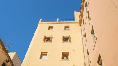 Güneşin altındaki mavi gökyüzüne karşı eski binaların çatısının alçak açısı.