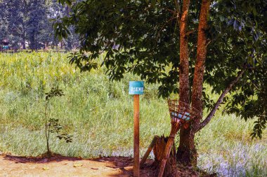 Assam, Hindistan 'da Chandubi Gölü yakınlarında bir yol kenarında bir ağaç ve bir tabela.