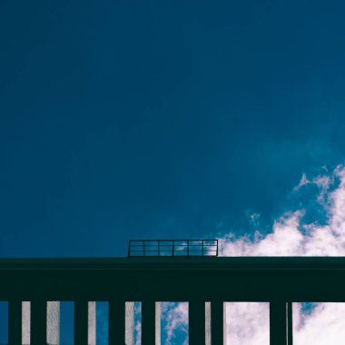 Beyaz bulutlu mavi gökyüzüne karşı metal bir köprü.