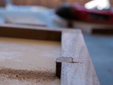 Marangoz oduncudaki fazladan odunları kestikten sonra bir kutunun üzerine talaş bırakılmış.