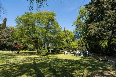 Valleggio sul Mincio, Veneto bölgesindeki Giardino Sigurta güzel parkında dinlenen insanlar.