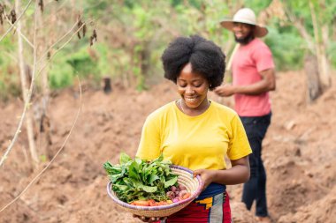 Bir sepet sebze taşıyan Afrikalı çiftçinin portresi.