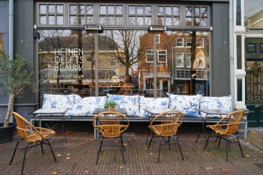 Bir restoranın terasında masanın etrafında rahat sandalyeler ve kanepe.