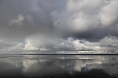 Bulutlu bir günde, dağların yakınında güzel bir deniz manzarası.