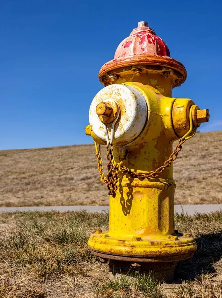 Eine Vertikale Nahaufnahme Eines Rostgelben Feuerhydranten Auf Einem Ländlichen Feld — Stockfoto