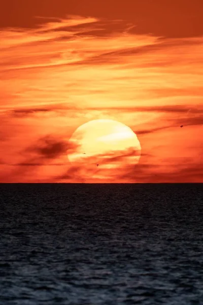 Вертикаль Большого Перламутрового Солнца Запечатленного Красном Закатном Небе Над Спокойным — стоковое фото