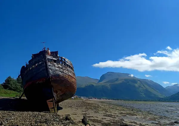 Opuštěná Loď Pobřeží Horami Oblohou Pozadí — Stock fotografie