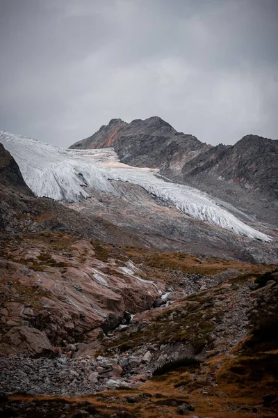Een Verticaal Schot Van Rotsachtige Besneeuwde Bergen Een Sombere Dag — Stockfoto
