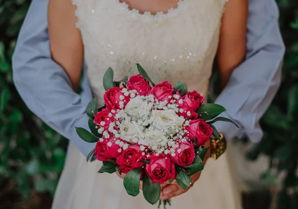ピンクと白のバラの彼らの結婚式の花束を保持新郎と橋のクローズアップショット — ストック写真