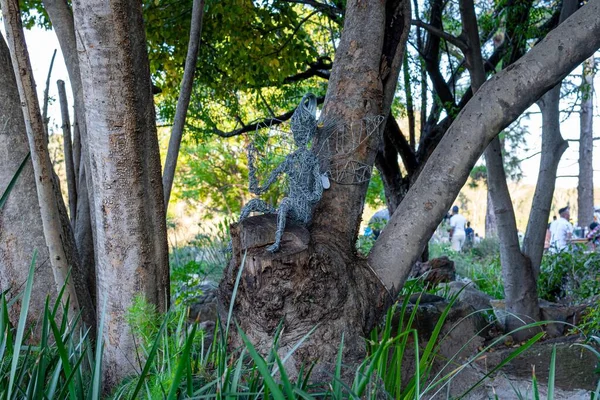 Zbliżenie Ujęcie Drucianej Rzeźby Wróżki Siedzącej Pniu Drzewa — Zdjęcie stockowe