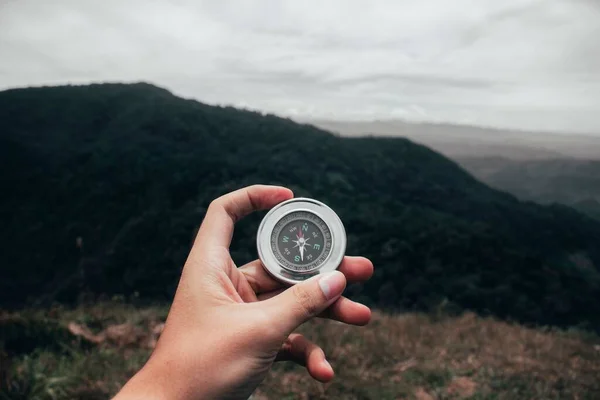 stock image A human hand holding compass in background of forest