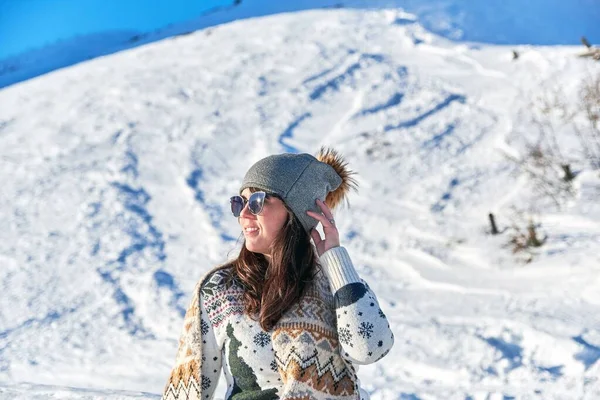 一位戴着太阳镜和围巾的女游客在雪山上欣赏美丽的风景 — 图库照片