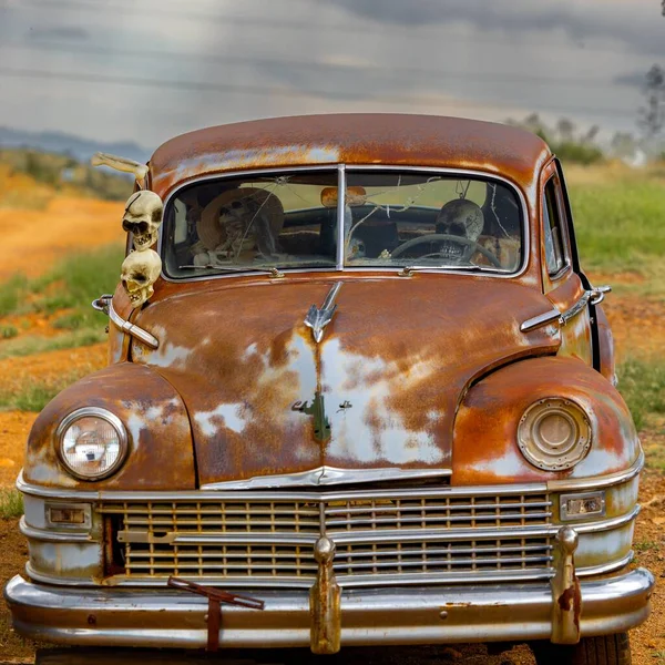一辆陈旧不堪 锈迹斑斑 废弃的旧车 上挂着陈腐的骷髅 在乡间田里腐烂 — 图库照片